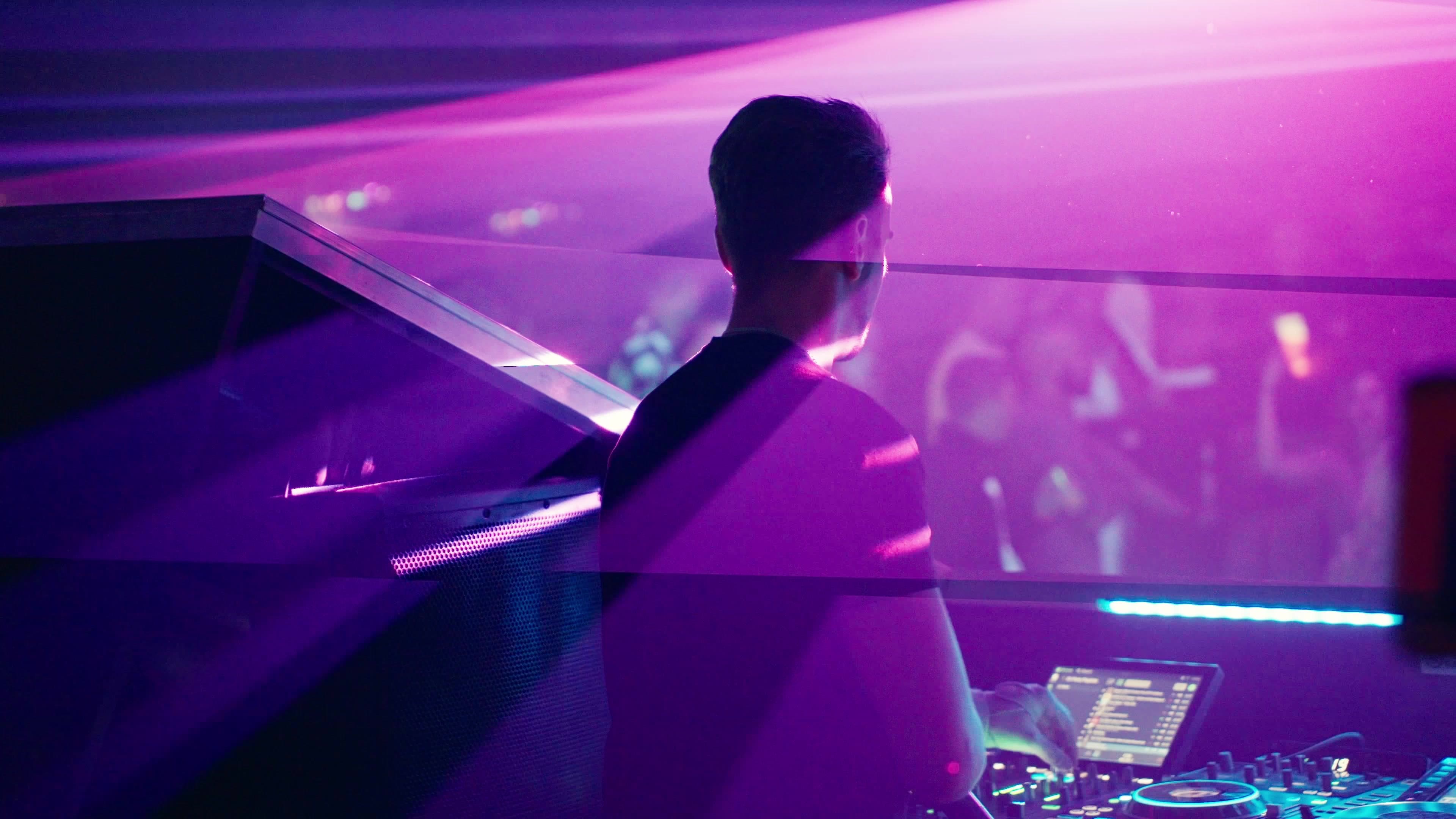 DJ von hinten am Mischpult im violetten Licht
