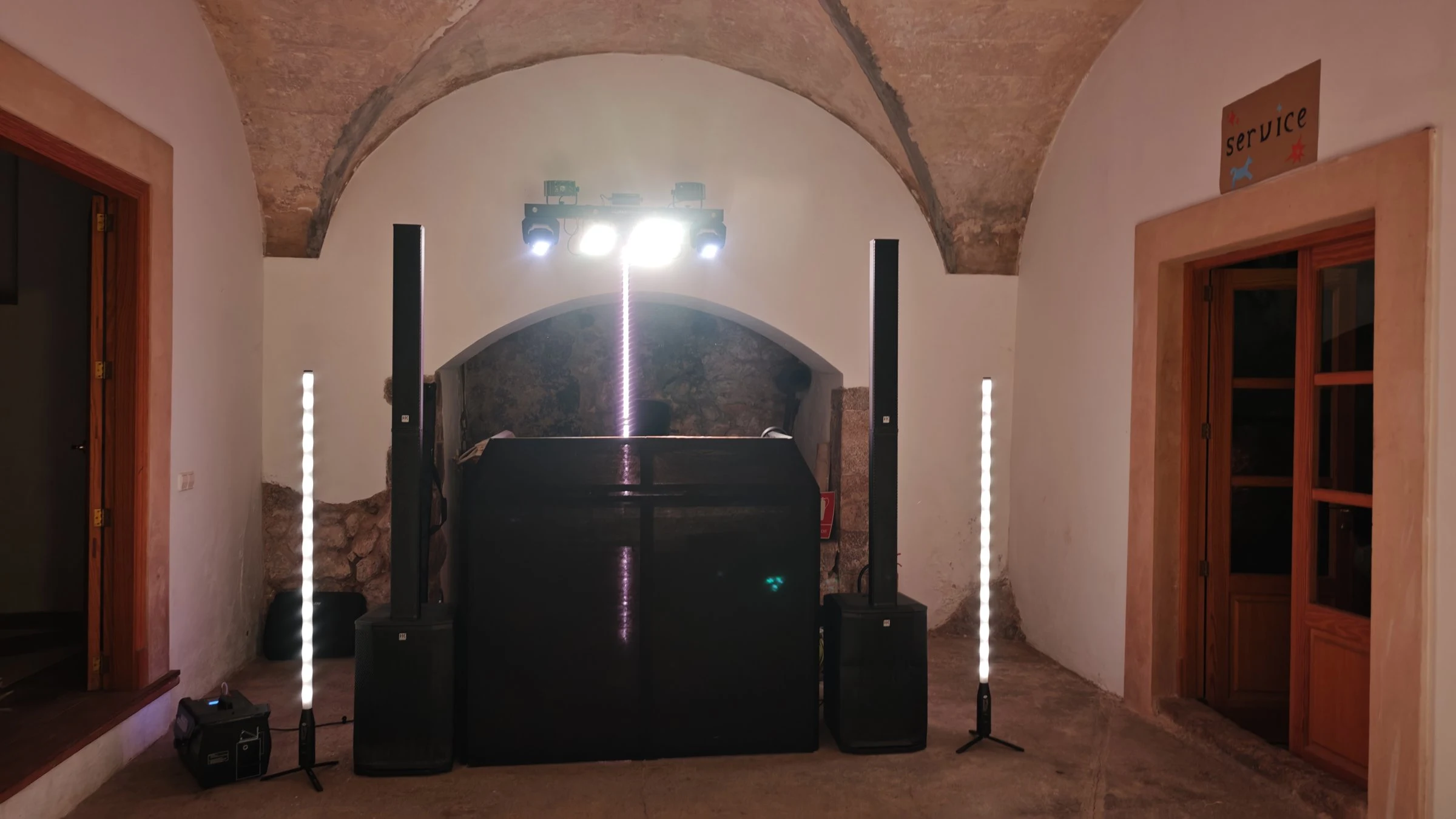 Party setup in a vaulted room with column speakers, LED tubes, light bar and DJ booth in Bunyola